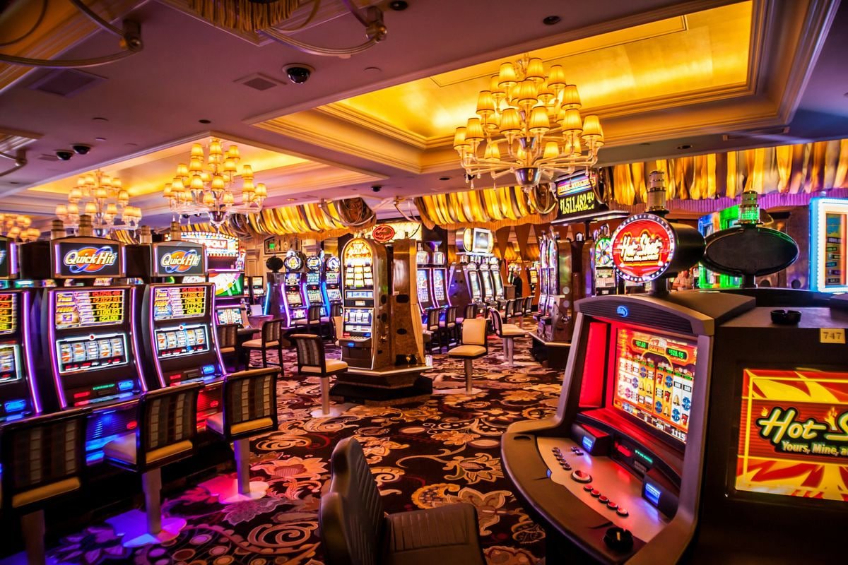 Dealer Live Sic Bo di platform zonaslot sedang melempar tiga dadu ke dalam kurungan transparan dengan kamera multi-sudut yang menampilkan hasil secara real-time